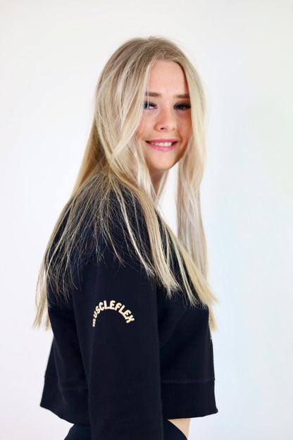 Side view of woman in black Lioness Cropped Crewneck Jumper, highlighting the comfortable and trendy cropped design, ideal for casual outings.