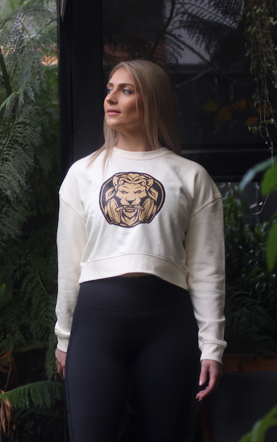 Woman wearing white Lioness Cropped Crewneck Jumper, combining style and comfort with breathable fabric, perfect for casual and athletic wear.